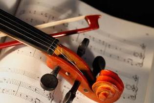 小提琴和琴弓放在乐谱上.